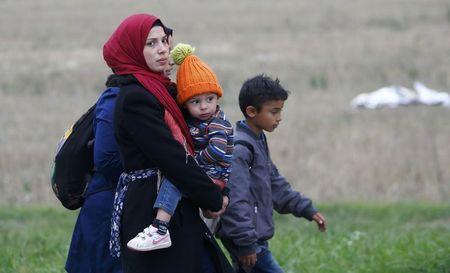 Migrants walk as they cross the border from Hungary to Austria in Nickelsdorf, September 11, 2015. PHOTO BY REUTERS/Leonhard Foeger