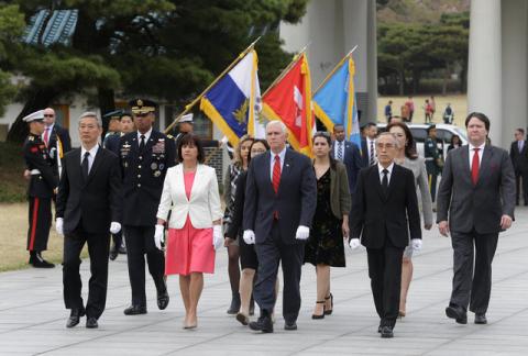 U.S. Vice President Mike Pence, center, and his wife Karen, center left, inspect hour guard upon their arrival at the National Cemetery in Seoul, South Korea, Sunday, April. 16, 2017. PHOTO BY REUTERS/Ahn Young-joon