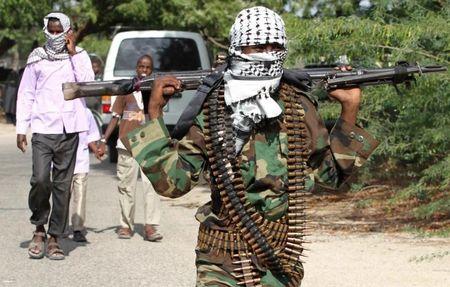 A member of Somalia's hardline al Shabaab rebel group walks with a machine gun after attending Eid al-Adha prayers inside a football stadium north of the capital Mogadishu, November 16, 2010. PHOTO BY REUTERS/Feisal Omar