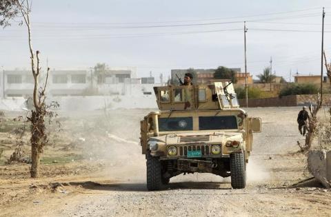 Military vehicles of the Iraqi security forces make their way on the outskirts of Baiji, north of Baghdad, December 8, 2014. PHOTO BY REUTERS/Ahmed Saad