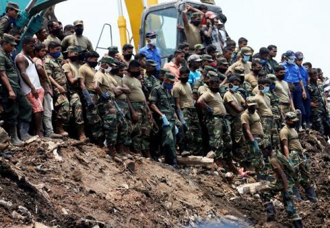 Members of the military wait until another rescue team recovers a dead victim during a rescue mission after a garbage dump collapsed and buried dozens of houses in Colombo, Sri Lanka, April 16, 2017. PHOTO BY REUTERS/Dinuka Liyanawatte