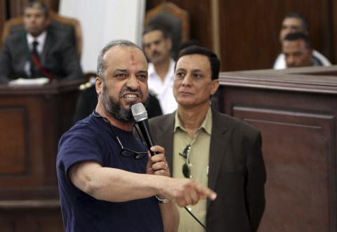 Member of the Muslim Brotherhood Mohamed Beltagy (L) speaks during his trial at a court in Cairo