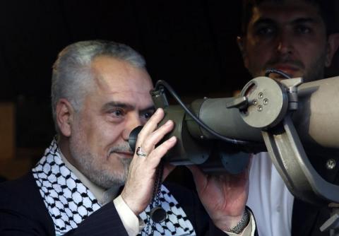 Mohammad Reza Rahimi uses a pair of binoculars as he looks towards the Israeli border in the Iranian garden at Maroun al-Ras village near the Israeli border in southern Lebanon, May 3, 2012. PHOTO BY REUTERS/Ali Hashisho