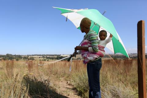 A mother holds a tape as she marks vacant land in Olievenhoutbosch near Centurion, South Africa, March 12, 2018. PHOTO BY REUTERS/Siphiwe Sibeko