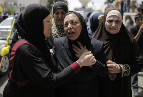 The mother (C) of Palestinian man Nadim Nuwara, who was shot dead by Israeli forces on Thursday, mourns during his funeral in the West Bank city of Ramallah, May 16, 2014. PHOTO BY REUTERS/Ammar Awad