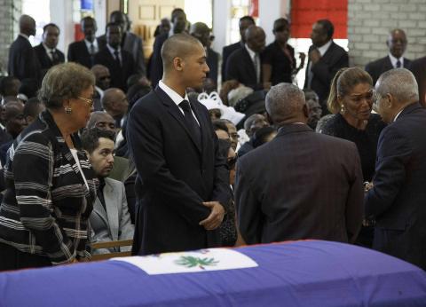 Mourners greet Michele Bennett (2nd R), the ex-wife of Haiti's former dictator Jean-Claude "Baby Doc" Duvalier, and Duvalier's son Francois Nicholas Duvalier (2nd L) during Duvalier's private funeral mass at the St. Louis de Gonzague school chapel in Port-au-Prince