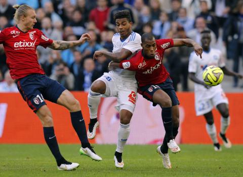 Olympique Marseille's Mario Lemina (C) challenges Lille's Simon Kjaer (L) and Djibril Sidibe during their French Ligue 1 soccer match at the Velodrome stadium in Marseille, December 21, 2014. PHOTO BY REUTERS/Jean-Paul Pelissier