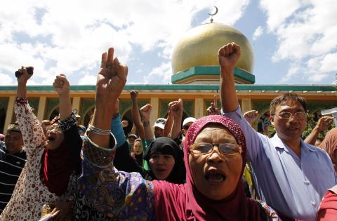 Members of a Muslim group participate in a unity walk before the start of a program to mark the upcoming signing of the final agreement between the Philippine government and Muslim rebels in Manila