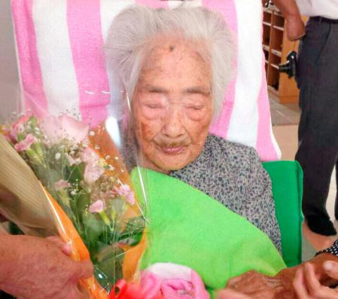 Nabi Tajima, born in 1900, holds a bouquet in Japanese southwestern island of Kikaijima, Kagoshima Prefecture, Japan, in this photo taken in 2015 and released by Kyodo. PHOTO BY REUTERS/Kyodo
