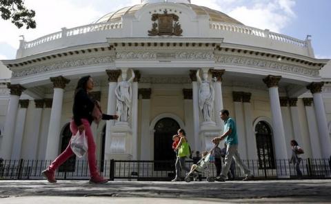 People walk past the National Assembly building during a session in Caracas, December 23, 2015. PHOTO BY REUTERS/Carlos Garcia Rawlins