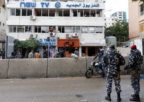 Policemen stand guard as workers remove broken glass from the headquarters of Lebanese television channel al-Jadeed, after demonstrators attacked the channel's headquarters on Tuesday, in Beirut, Lebanon, February 15, 2017. PHOTO BY REUTERS/Mohamed Azakir
