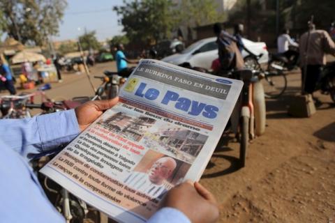 A man reads newspaper headlines that talk about the al Qaeda attack on the Splendid Hotel and Cappuccino that killed at least 28 people from at least seven countries in Ouagadougou, Burkina Faso, January 18, 2016. PHOTO BY REUTERS/Joe Penney