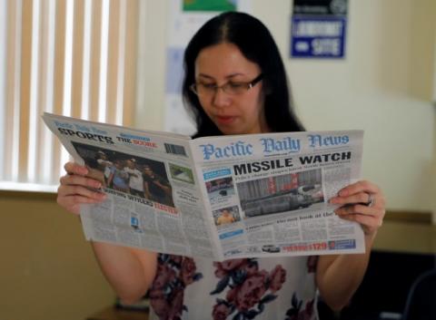 A hotel receptionist reads a local newspaper in Tamuning, Guam, a U.S. Pacific Territory, August 12, 2017. PHOTO BY REUTERS/Erik De Castro