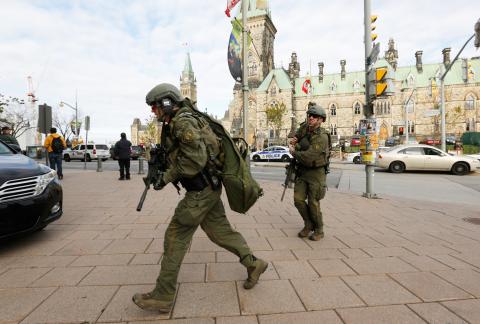 Armed RCMP officers head towards the Langevin Block on Parliament Hill following a shooting incident in Ottawa October 22, 2014. PHOTO BY REUTERS/Chris Wattie
