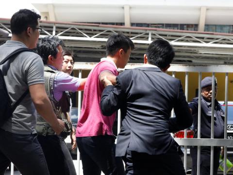 Media journalists scuffle with a North Korean official (in pink) as they try for a door stop at the morgue at Kuala Lumpur General Hospital where Kim Jong Nam's body is held for autopsy in Malaysia, February 15, 2017. PHOTO BY REUTERS/Edgar Su