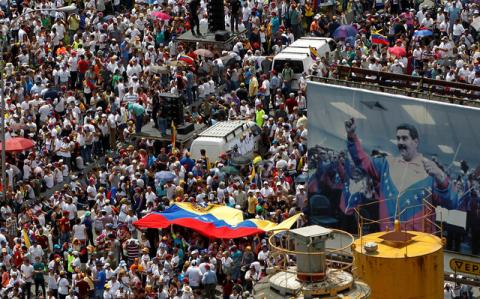 Opposition supporters take part in a rally against Venezuela's President Nicolas Maduro next to a poster of him in Caracas, Venezuela, October 26, 2016. PHOTO BY REUTERS/Christian Veron