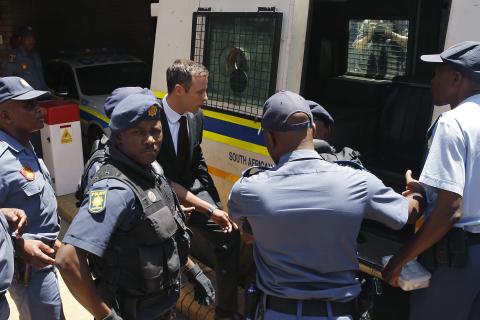 South African Olympic and Paralympic sprinter Oscar Pistorius (C) enters a police van after his sentencing at the North Gauteng High Court in Pretoria, October 21, 2014. PHOTO BY REUTERS/Siphiwe Sibeko