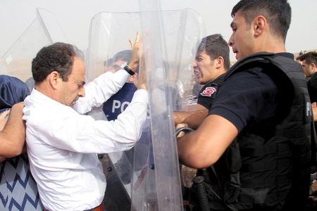 A parliamentarian from the pro-Kurdish Peoples' Democratic Party, Osman Baydemir (L) scuffles with riot police as he walks with his party members to the southeastern town of Cizre, near Idil in Sirnak province, Turkey, September 10, 2015. PHOTO BY REUTERS/Sertac Kayar