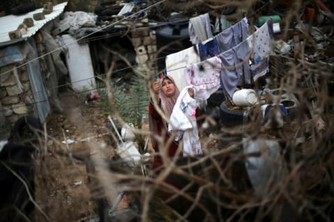 A Palestinian woman hangs laundry on a rope to dry outside her dwelling in Khan Younis in the southern, Gaza Strip. PHOTO BY REUTERS/Ibraheem Abu Mustafa