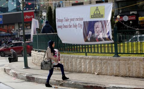 A Palestinian woman walks past a banner against a promise by U.S. President-elect Donald Trump to relocate the U.S. embassy to Jerusalem, in the West Bank city of Nablus, January 19, 2017. PHOTO BY REUTERS/Abed Omar Qusini