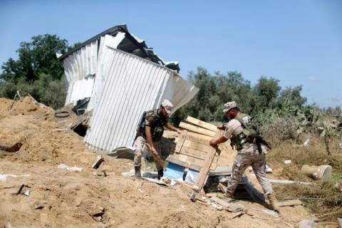 Members of Palestinian security forces loyal to Hamas survey a Hamas site after it was hit by an Israeli air strike in the northern Gaza Strip, August 22, 2016. PHOTO BY REUTERS/Ibraheem Abu Mustafa