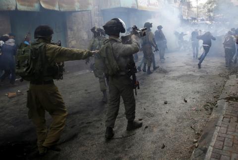 Palestinians run away from Israeli troops during clashes following a protest demanding Israel to return the dead bodies of Palestinians who allegedly stabbed Israelis, in the West Bank city of Hebron, October 27, 2015. PHOTO BY REUTERS/Mussa Qawasma