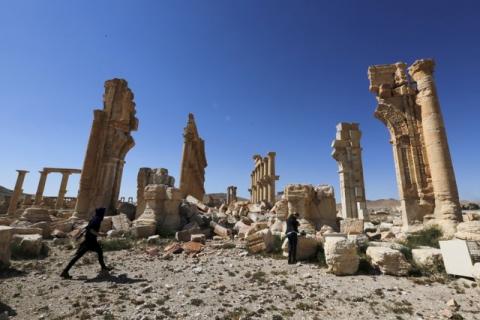 Journalists walk near the remains of the Monumental Arch in the historical city of Palmyra, in Homs Governorate, Syria, April 1, 2016. PHOTO BY REUTERS/Omar Sanadiki