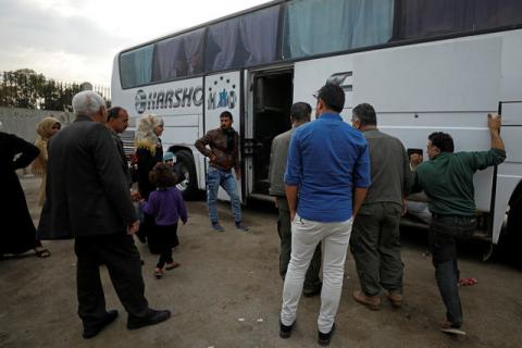 Passengers wait in Qamishli city in Syria's Kurdish-held northeast to embark on a bus headed for government-controlled Aleppo, Syria, May 7, 2017. PHOTO BY REUTERS/Rodi Said