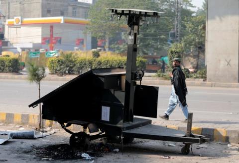A passerby looks at a mobile CCTV unit destroyed during clashes with protesters near the Faizabad junction in Islamabad, Pakistan, November 26, 2017. PHOTO BY REUTERS/Caren Firouz
