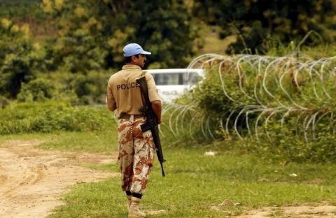 A UN peacekeeping force soldier patrols as he guards an area where severals wells containing the remains of massacred civilians were found, in Duekoue, west Ivory Coast, June 23, 2015. PHOTO BY REUTERS/Luc Gnago