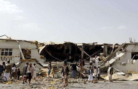 People gather outside a fabric factory after a Saudi-led air strike hit it in Yemen's capital Sanaa, July 10, 2015. PHOTO BY REUTERS/Khaled Abdullah
