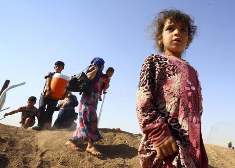People who fled from the violence in Mosul walk inside the Khazer refugee camp on the outskirts of the Kurdish city of Arbil