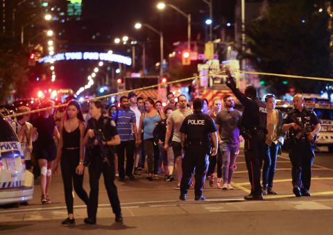 People leave an area taped off by the police near the scene of a mass shooting in Toronto, Canada, July 22, 2018. PHOTO BY REUTERS/Chris Helgren