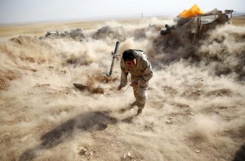 A Kurdish Peshmerga fighter launches mortar shells towards Zummar, controlled by Islamic State (IS), near Mosul, September 15, 2014. PHOTO BY REUTERS/Ahmed Jadallah