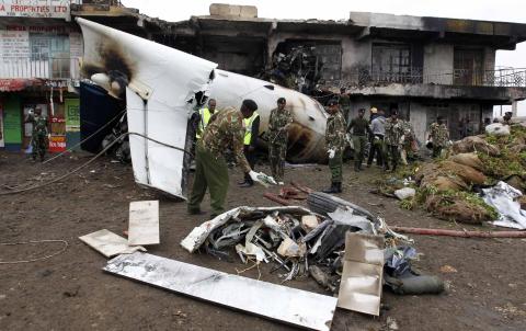 Security personnel attempt to retrieve bodies from the wreckage of a cargo plane that crashed into a commercial building on the Utawala estate on the outskirts of Kenya's capital Nairobi
