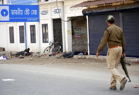 A policeman walks past injured tribal demonstrators after a clash during a protest at Dekiajuli town in the northeastern Indian state of Assam December 24, 2014. PHOTO BY REUTERS/Stringer