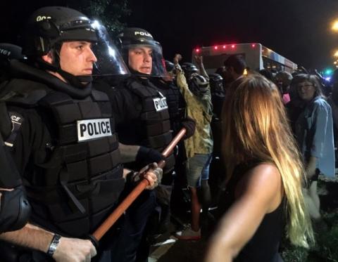 Police officers wearing riot gear block a road during protests after police fatally shot Keith Lamont Scott in the parking lot of an apartment complex in Charlotte, North Carolina, U.S., September 20, 2016. PHOTO BY REUTERS/Adam Rhew/Charlotte Magazine