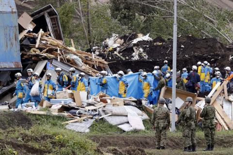 Police officers and members of the Japan Self-Defense Forces (JSDF) carry a missing person found from an area damaged by a landslide caused by an earthquake in Atsuma town, Hokkaido, northern Japan, September 8, 2018. PHOTO BY REUTER/Kyodo