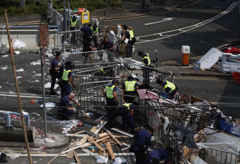 Police remove a barricade left by pro-democracy protesters on a main road leading to the financial Central district in Hong Kong