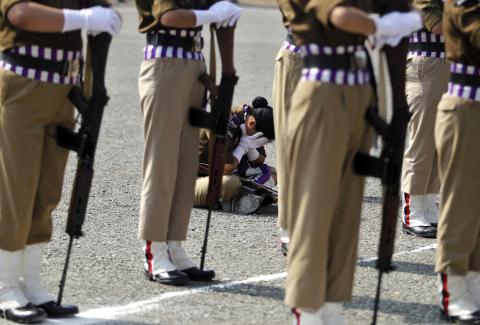 A member of a female Indian police contingent holds her face in her hands as she sits during a parade to mark Police Commemoration Day in Zewan, on the outskirts of Srinagar, October 21, 2014. PHOTO BY REUTERS/Danish Ismail