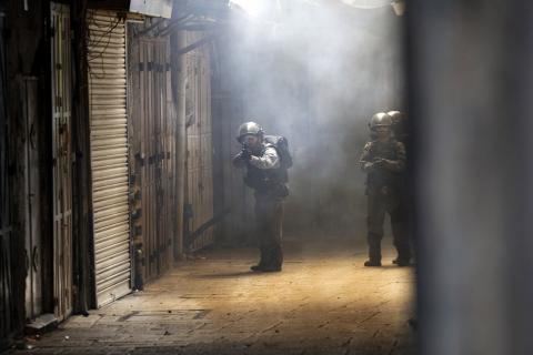 An Israeli policeman aims his weapon during clashes with Palestinians inside the old city of Jerusalem, October 30, 2014. PHOTO BY REUTERS/Finbarr O'Reilly