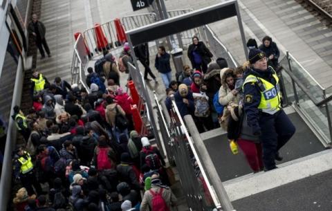 Police organize the line of refugees at on the stairway leading up from the trains arriving from Denmark at the Hyllie train station outside Malmo, Sweden, November 19, 2015. PHOTO BY REUTERS/Johan Nilsson