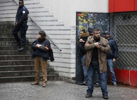 French police check a pedestrian as they secure the area after a man was shot dead at a police station in the 18th district in Paris, France, January 7, 2016. PHOTO BY REUTERS/Philippe Wojazer