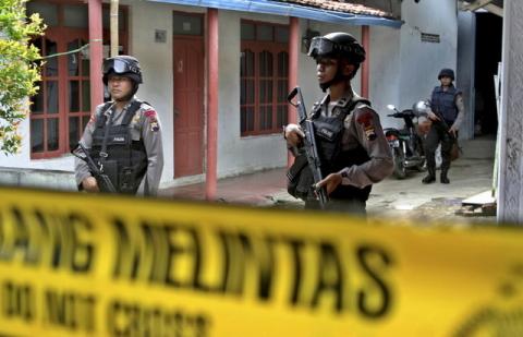 Armed police stand in front a house whose owner was arrested during a raid in the Langgen village in Tegal, Indonesia Central Java, January 15, 2016. PHOTO BY REUTERS/Oky Lukmansyah