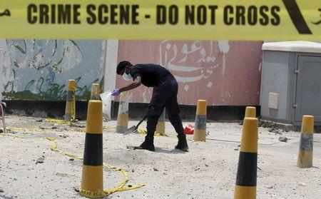 An explosives specialist police officer collects samples after a bomb blast in the village of Sitra, south of Manama, Bahrain, July 28, 2015. PHOTO BY REUTERS/Hamad I Mohammed