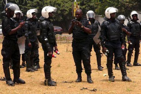 Police officers hold tear gas canisters during an opposition rally in Conakry April 20, 2015. REUTERS/Saliou Samb