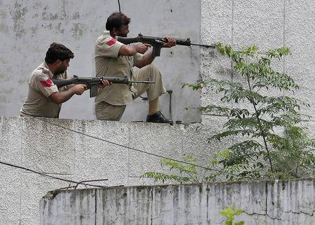 Indian policemen take their positions next to a police station during a gunfight at Dinanagar town in Gurdaspur district of Punjab, India, July 27, 2015. PHOTO BY REUTERS/Munish Sharma