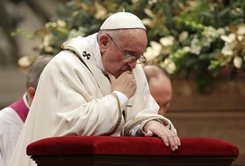Pope Francis kneels as he leads the Christmas night mass in Saint Peter's Basilica at the Vatican, December 24, 2014. PHOTO BY REUTERS/Max Rossi
