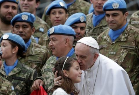 Pope Francis kisses a child as he poses with Argentinian United Nations soldiers during the weekly audience in Saint Peter's Square at the Vatican, February 3, 2016. PHOTO BY REUTERS/Max Rossi