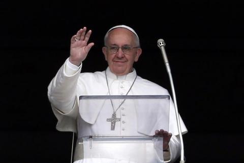 Pope Francis waves to the faithful as he appears at the window of his future private apartment in St. Peter's Square, during the Angelus prayer at the Vatican